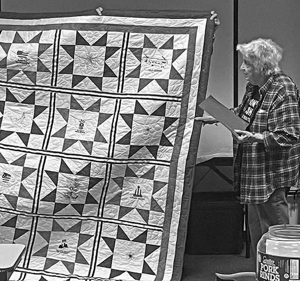 A quilt was accepted by Mary Scott (left) on behalf of John R. Scott who was unable to attend. He made the Army his career, focusing on helicopter repair. He became a flight engineer and flight engine instructor, and was deployed to Saudi Arabia in 1988 for Desert Storm. After retirement Scott returned to teaching Army helicopter instructors.
