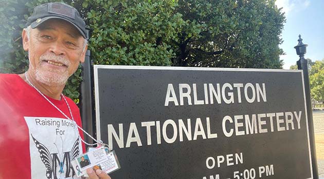 Photo courtesy of Hogan HillingHogan Hilling standing in front of Arlington National Cemetery on his journey across America to spread awareness about Mothers of Veteran Suicide.