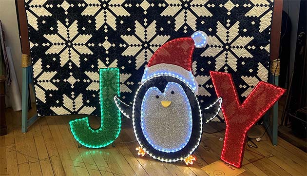 Photos by Shawn WhiteA holiday quilt made by Material Girls Quilt Guild and a holiday Joy decoration donated by Bob Hall.